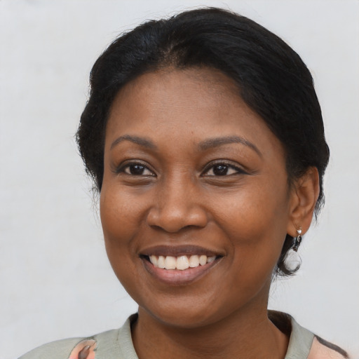 Joyful black young-adult female with short  black hair and brown eyes
