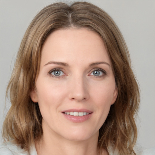 Joyful white young-adult female with medium  brown hair and grey eyes