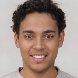 Joyful latino young-adult male with short  brown hair and brown eyes