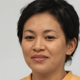 Joyful asian adult female with medium  brown hair and brown eyes