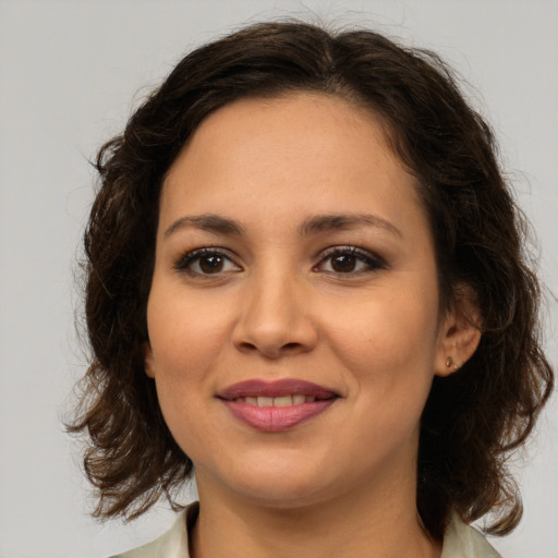 Joyful latino young-adult female with medium  brown hair and brown eyes