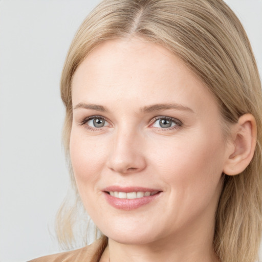 Joyful white young-adult female with long  brown hair and blue eyes