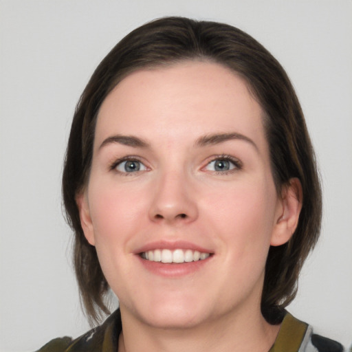 Joyful white young-adult female with medium  brown hair and grey eyes