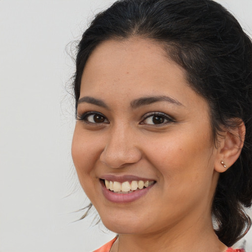 Joyful latino young-adult female with medium  brown hair and brown eyes