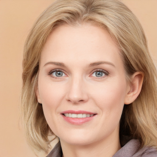 Joyful white young-adult female with medium  brown hair and blue eyes