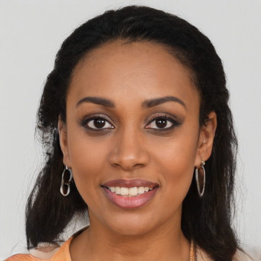 Joyful black young-adult female with long  brown hair and brown eyes