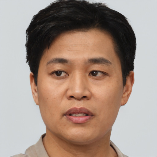 Joyful asian young-adult male with short  black hair and brown eyes