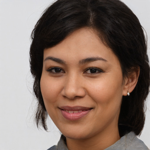 Joyful latino young-adult female with medium  brown hair and brown eyes