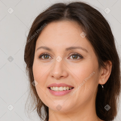 Joyful white adult female with long  brown hair and brown eyes