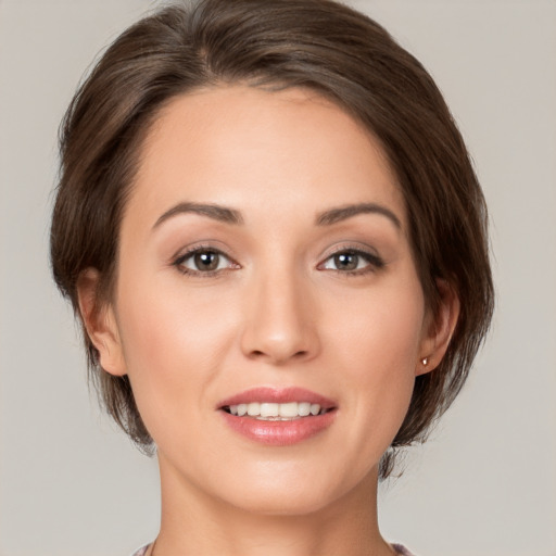 Joyful white young-adult female with medium  brown hair and grey eyes