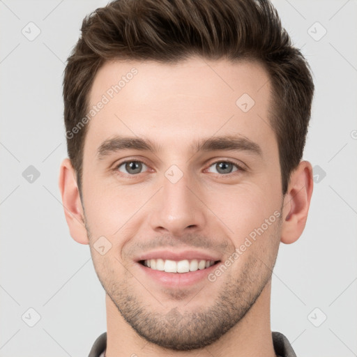 Joyful white young-adult male with short  brown hair and grey eyes