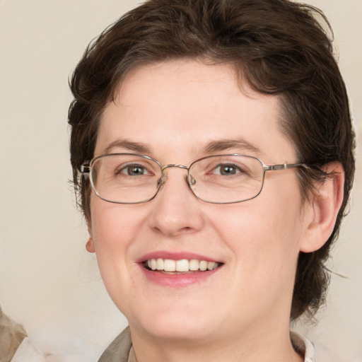 Joyful white adult female with medium  brown hair and green eyes