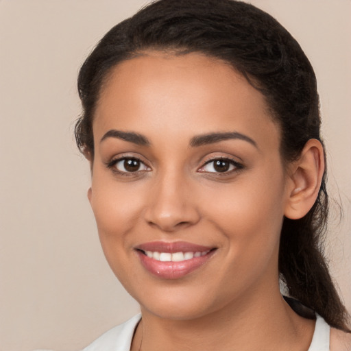 Joyful latino young-adult female with long  brown hair and brown eyes