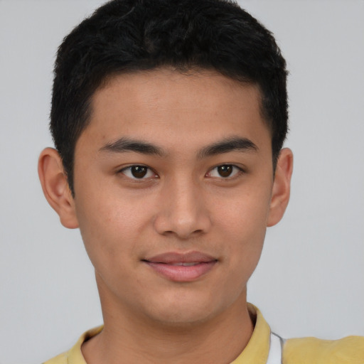 Joyful latino young-adult male with short  brown hair and brown eyes