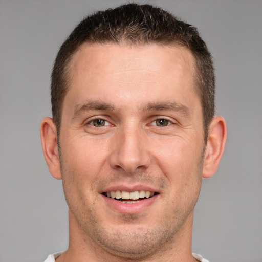 Joyful white young-adult male with short  brown hair and brown eyes