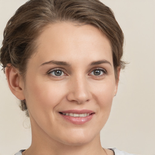 Joyful white young-adult female with medium  brown hair and grey eyes