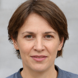 Joyful white adult female with medium  brown hair and grey eyes