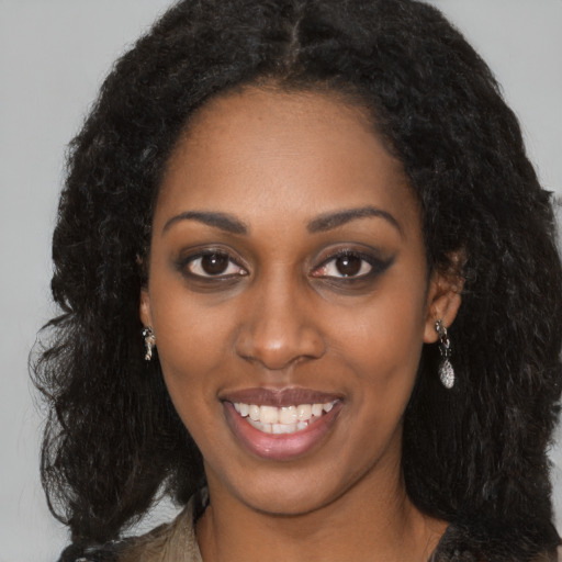 Joyful black young-adult female with long  black hair and brown eyes