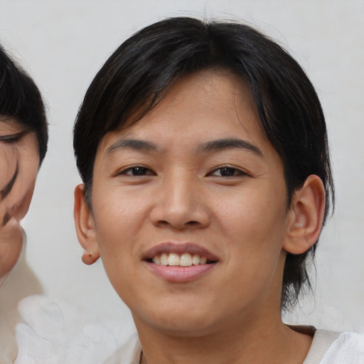 Joyful asian young-adult female with medium  brown hair and brown eyes