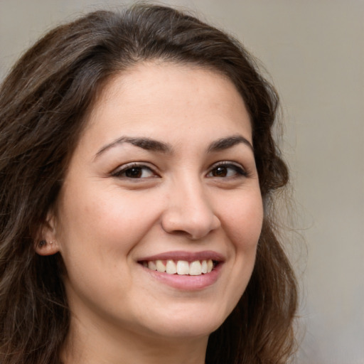 Joyful white young-adult female with long  brown hair and brown eyes