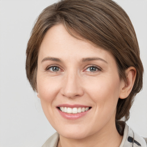 Joyful white young-adult female with medium  brown hair and grey eyes