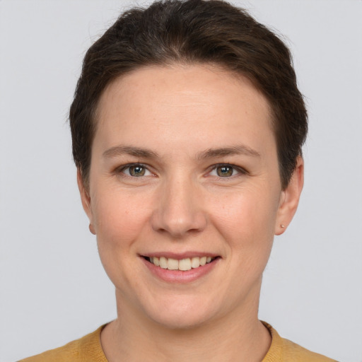 Joyful white young-adult female with short  brown hair and grey eyes