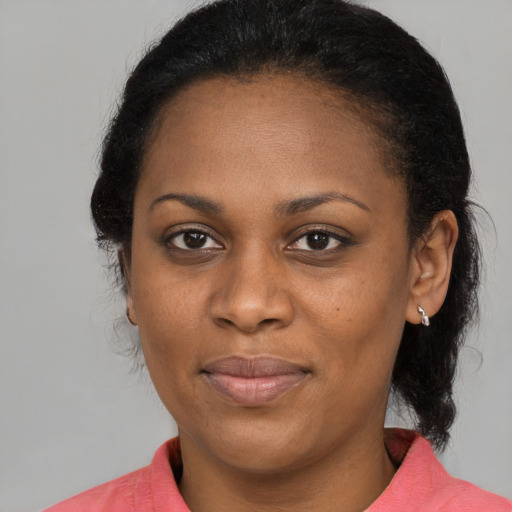 Joyful black adult female with medium  brown hair and brown eyes
