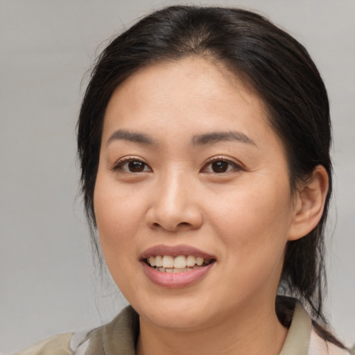 Joyful asian young-adult female with medium  brown hair and brown eyes