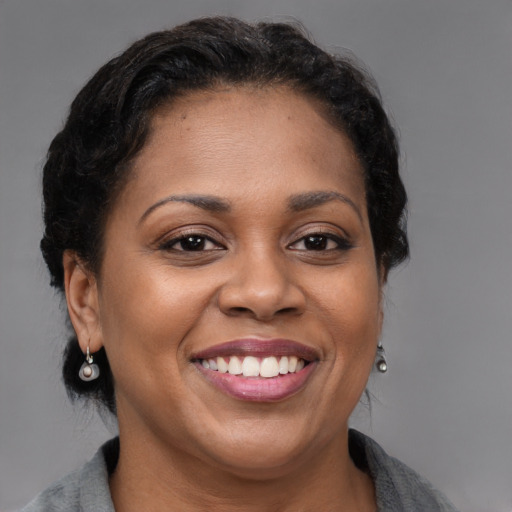 Joyful black adult female with medium  brown hair and brown eyes