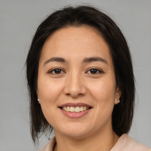 Joyful latino young-adult female with medium  brown hair and brown eyes