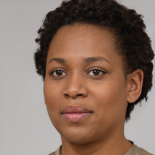 Joyful black young-adult female with short  brown hair and brown eyes