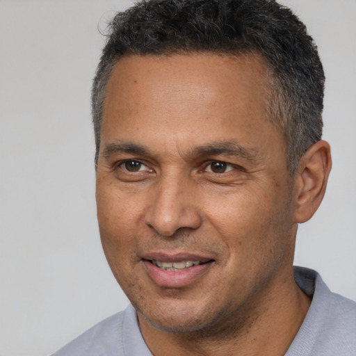 Joyful latino adult male with short  brown hair and brown eyes