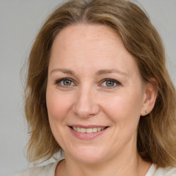 Joyful white adult female with medium  brown hair and blue eyes