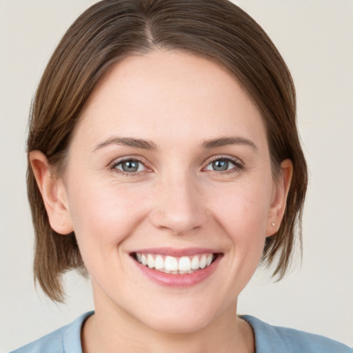 Joyful white young-adult female with medium  brown hair and grey eyes