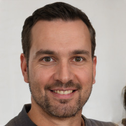 Joyful white adult male with short  brown hair and brown eyes