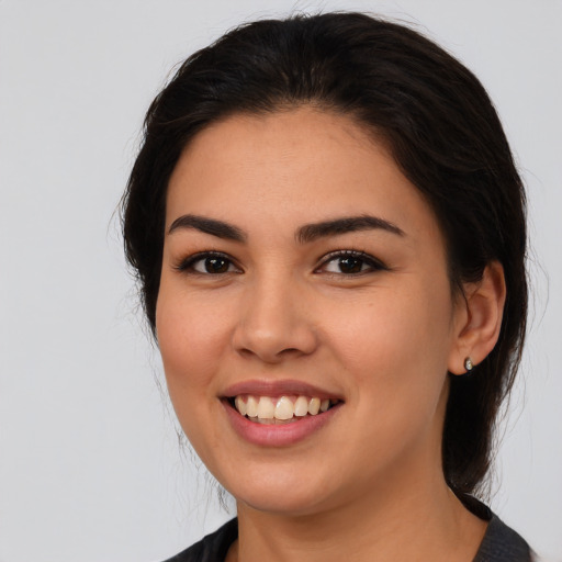 Joyful latino young-adult female with long  brown hair and brown eyes