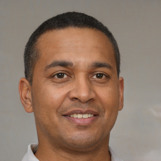 Joyful black young-adult male with short  brown hair and brown eyes