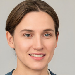 Joyful white young-adult female with medium  brown hair and grey eyes