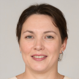 Joyful white adult female with medium  brown hair and grey eyes