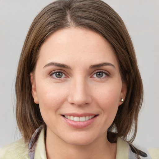 Joyful white young-adult female with medium  brown hair and grey eyes