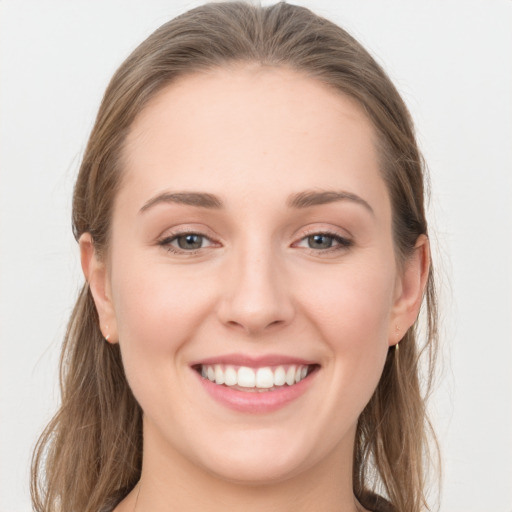 Joyful white young-adult female with long  brown hair and grey eyes