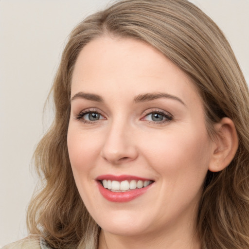 Joyful white young-adult female with long  brown hair and blue eyes