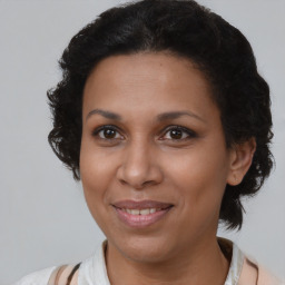 Joyful black adult female with medium  brown hair and brown eyes