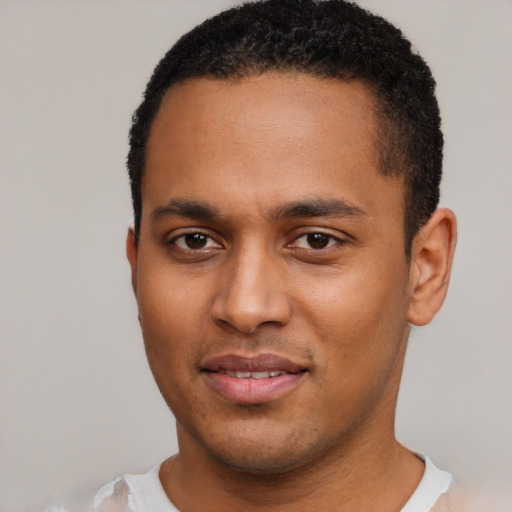 Joyful black young-adult male with short  black hair and brown eyes