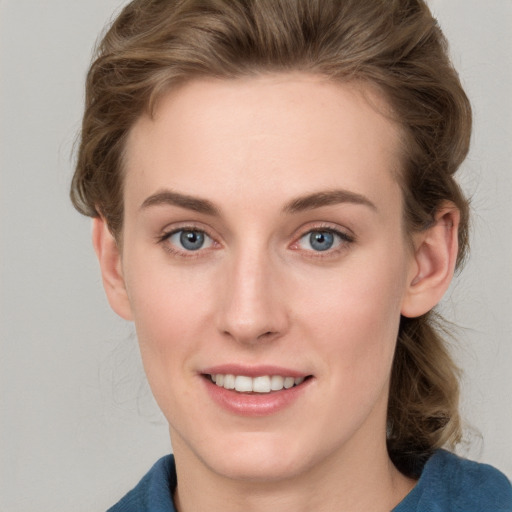 Joyful white young-adult female with medium  brown hair and blue eyes