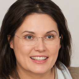 Joyful white adult female with medium  brown hair and green eyes