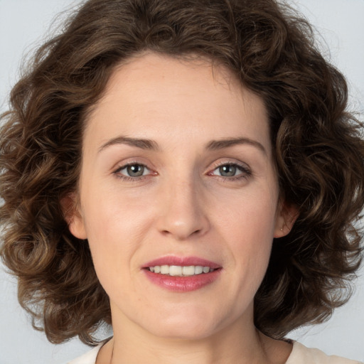 Joyful white young-adult female with medium  brown hair and green eyes