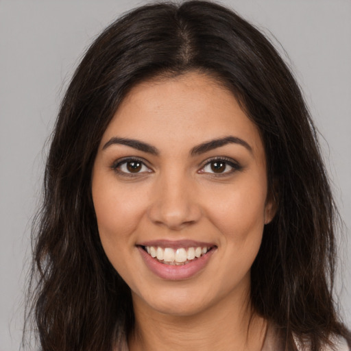 Joyful latino young-adult female with long  brown hair and brown eyes