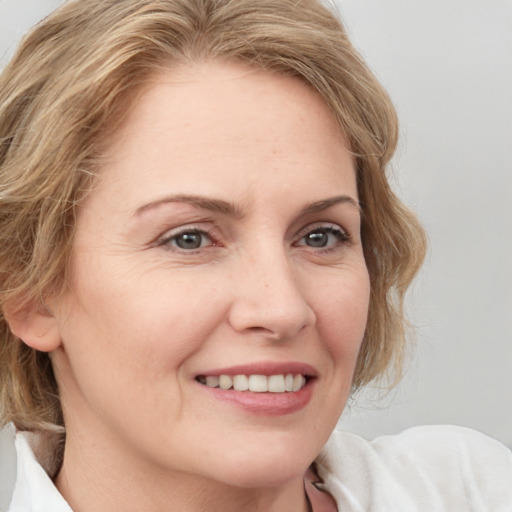 Joyful white adult female with medium  brown hair and blue eyes