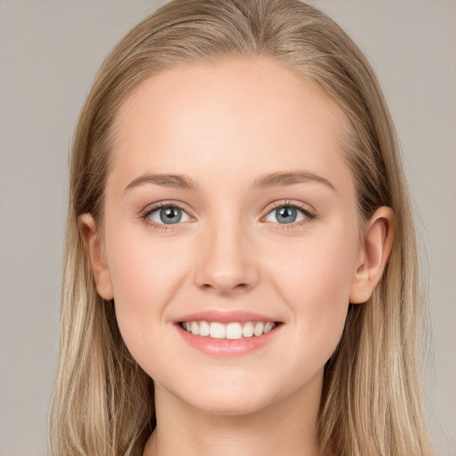 Joyful white young-adult female with long  brown hair and blue eyes